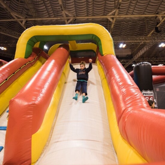 Kid in play area with inflatable slide